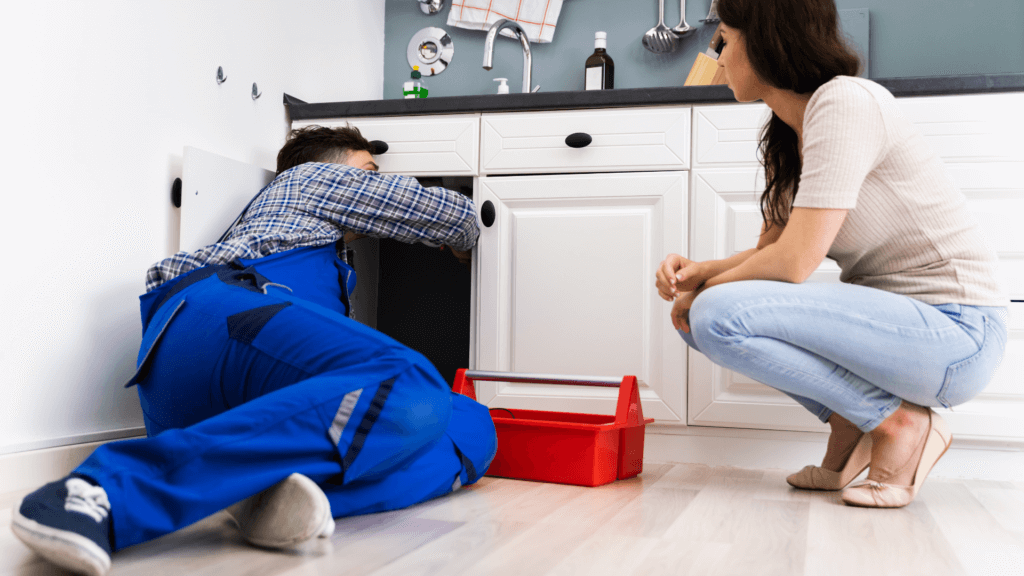 plumber working under a customers sink