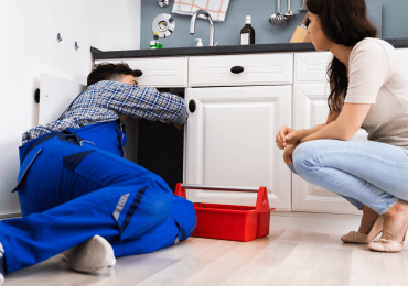 plumber working under a customers sink